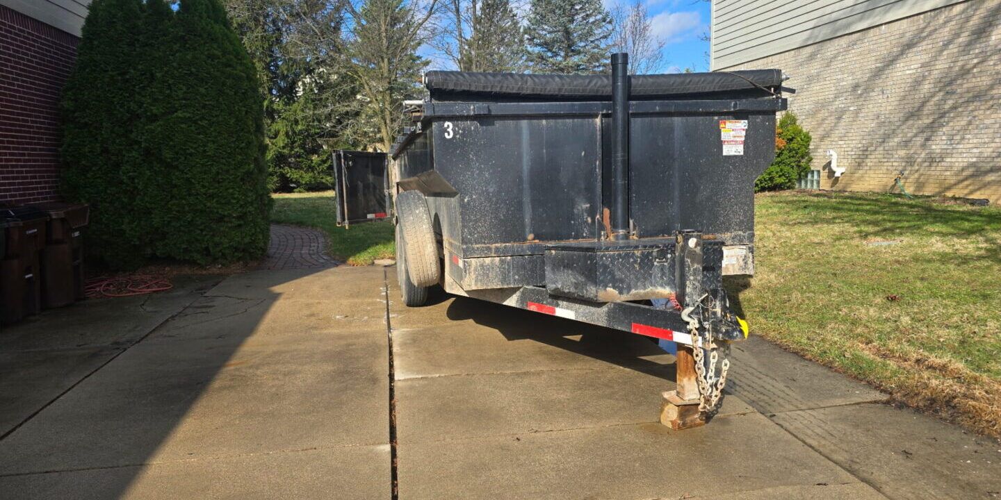 dumpster rental in Utica MI driveway safe trailer on residential driveway between houses