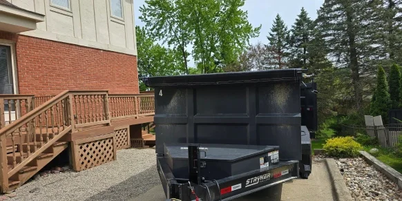 Dumpster trailer on driveway with wood protection
